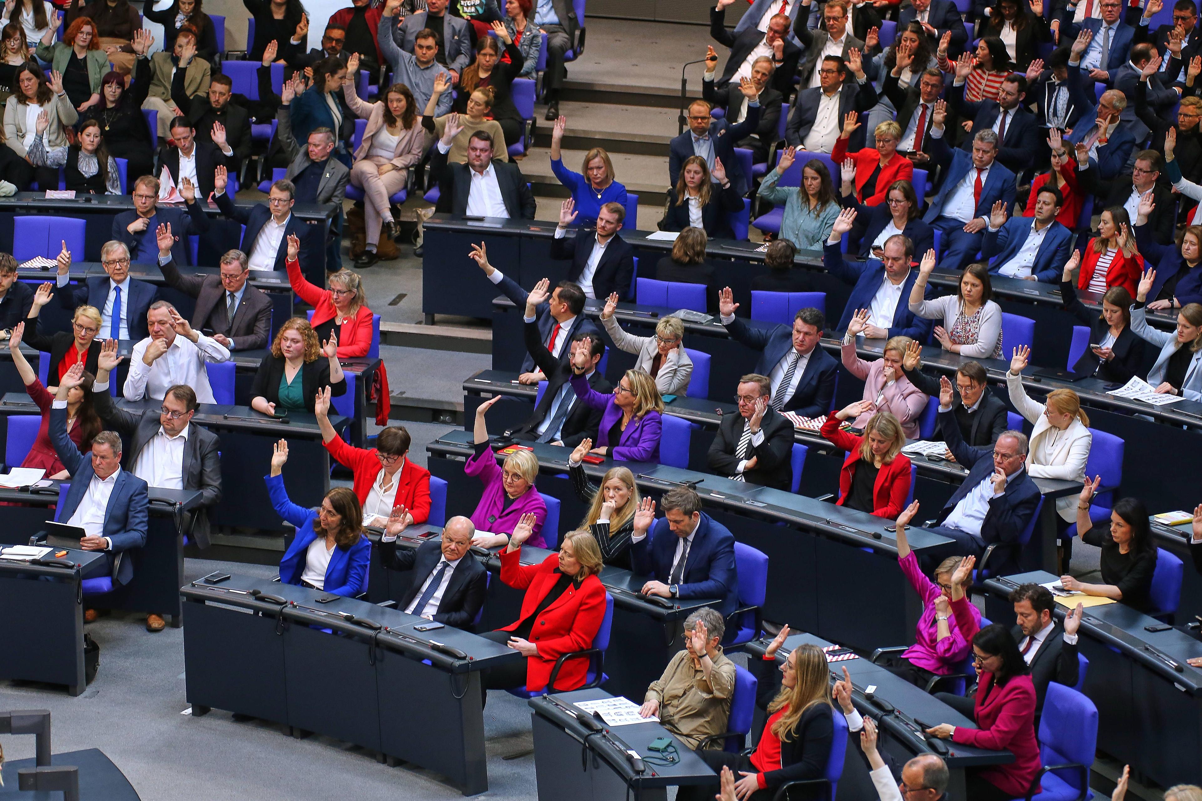 Abgeordnete der Linken und der SPD heben die Hände bei einer Abstimmung im Bundestag, 25. März 2025.