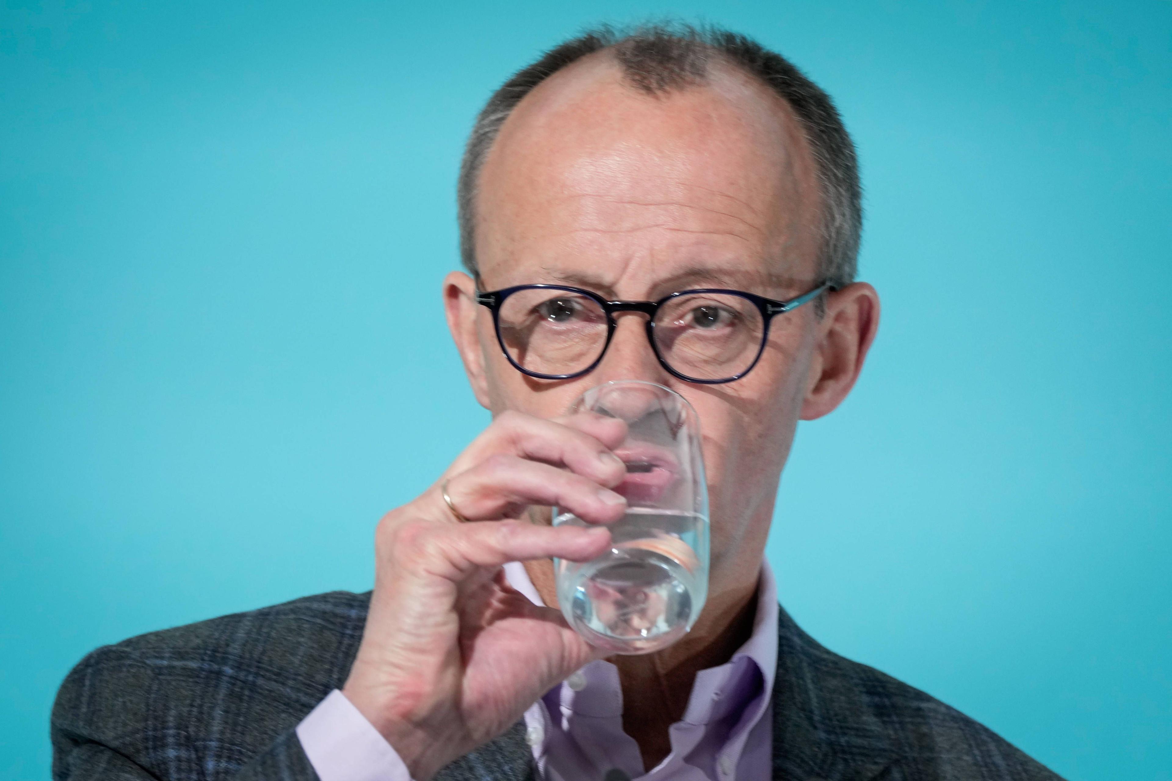 Friedrich Merz trinkt einen Schluck Wasser.