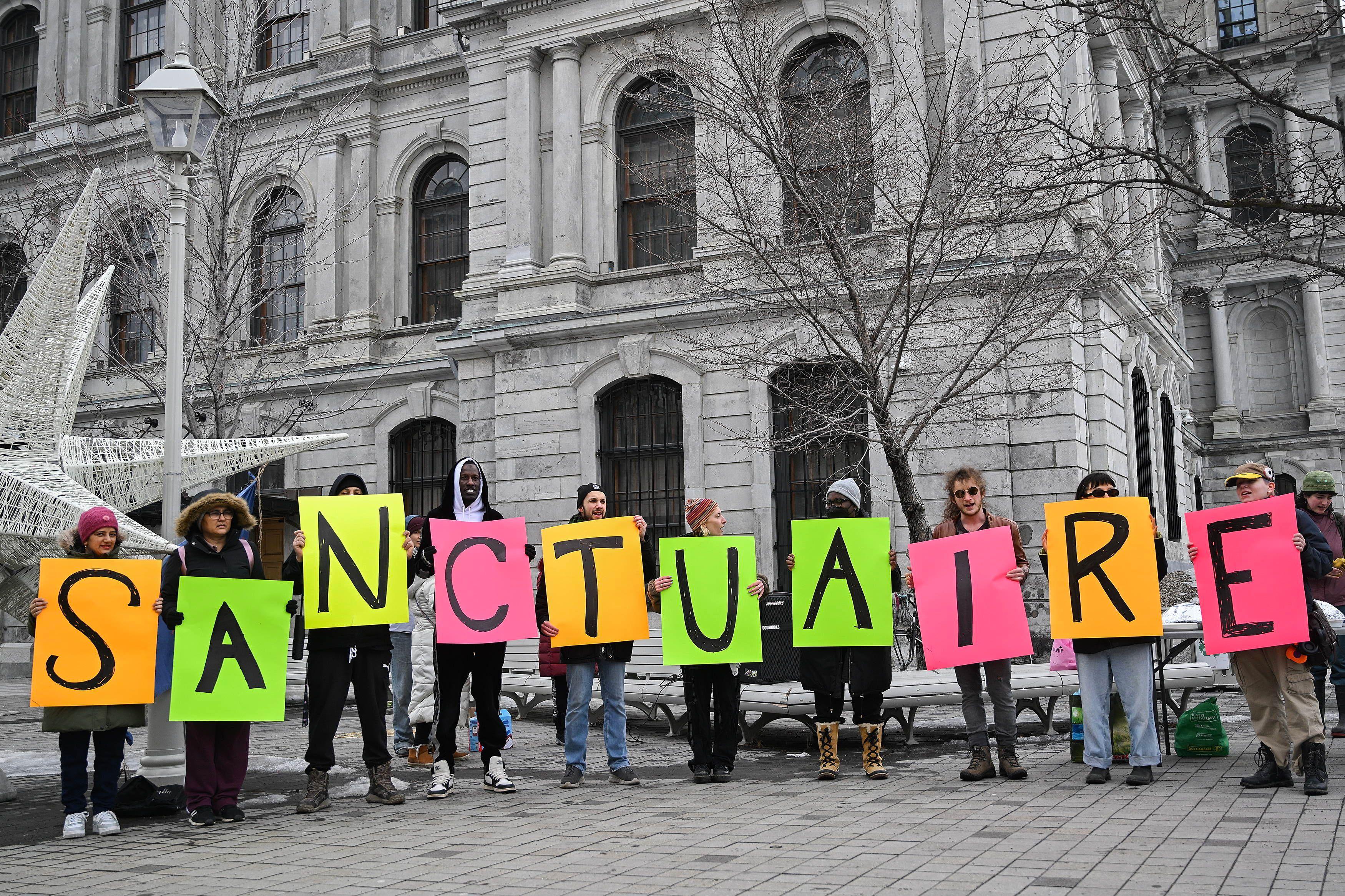 Menschen fordern vor dem Rathaus von Montreal, die Stadt solle eine »ville sanctuaire« werden.