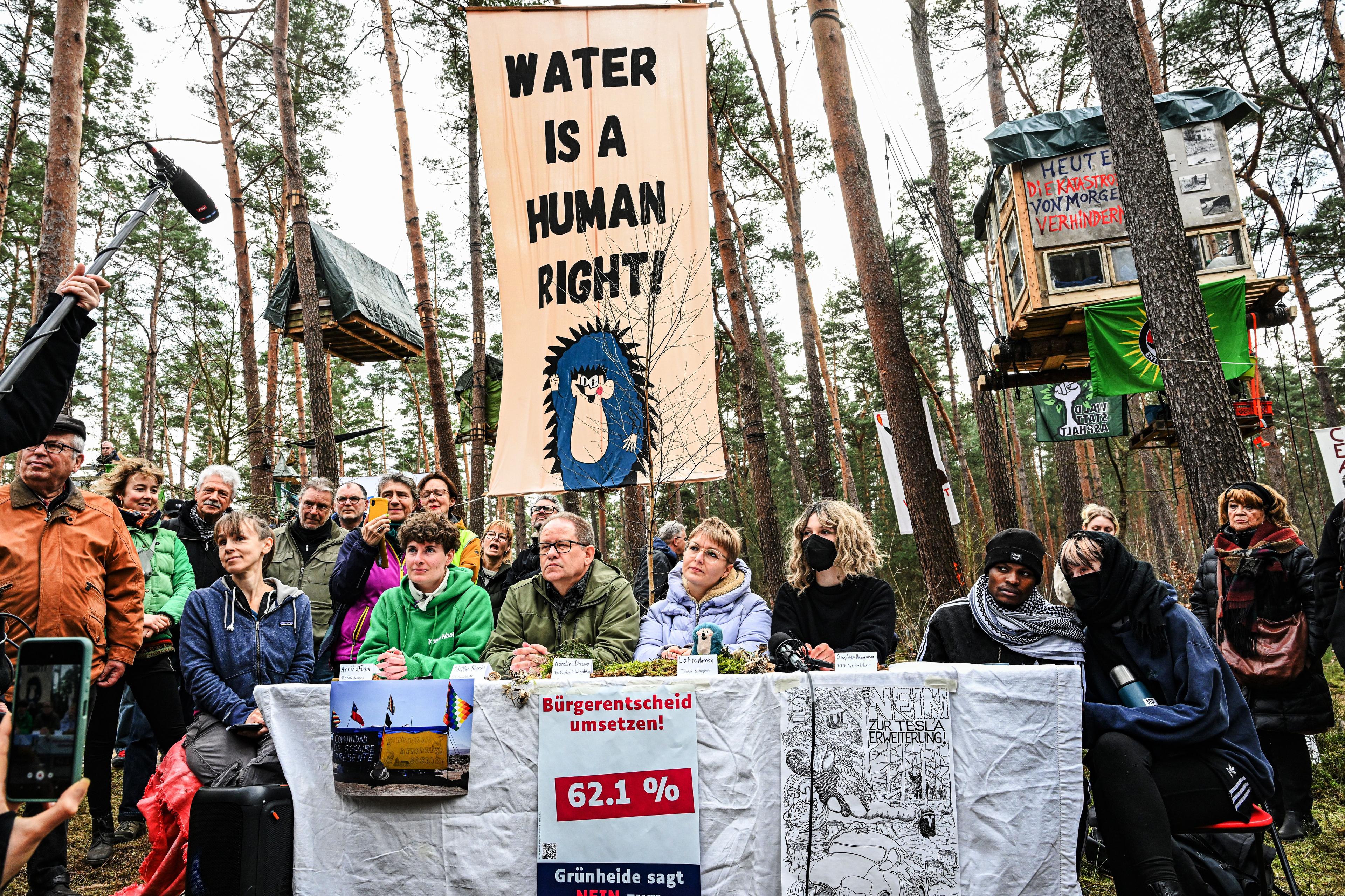 Im Protestcamp nahe der Gigafactory von Tesla versammeln sich Aktivistinnen und Anwohner zu einer Pressekonferenz.